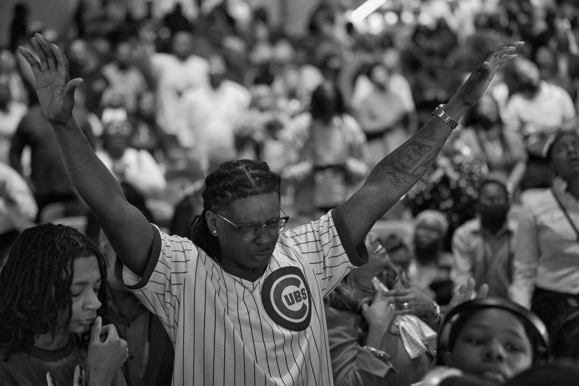 Black-and-white moment of worship with raised hands in congregation
