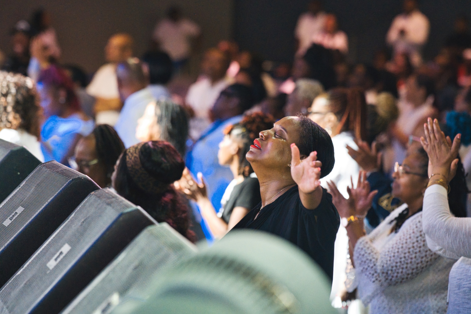 Woman worshipping with raised hands at service